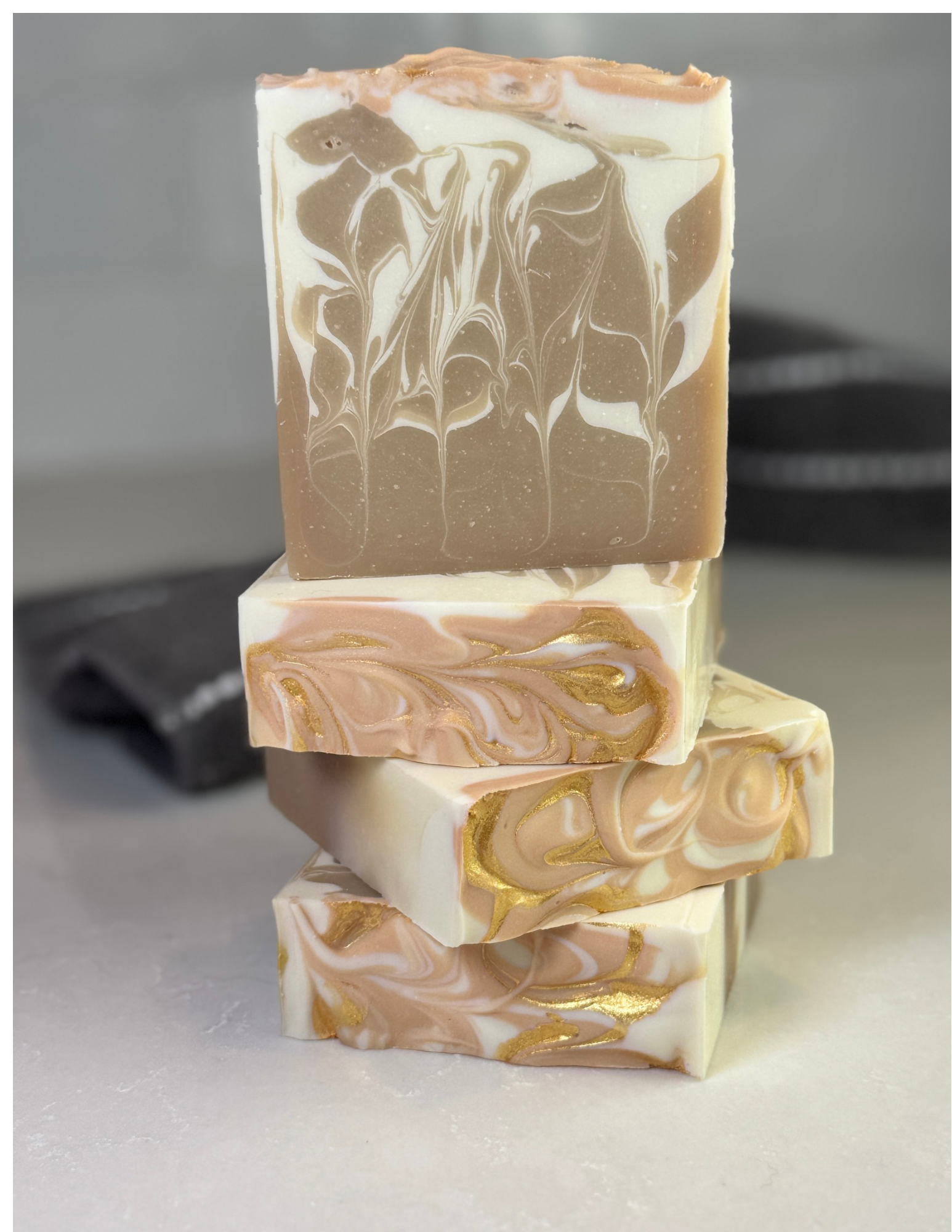 Stack of marbled soap bars on a neutral background