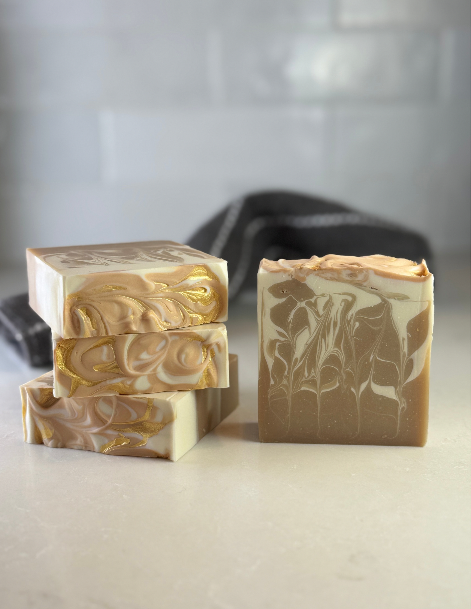 Three bars of soap with artistic designs on a neutral background