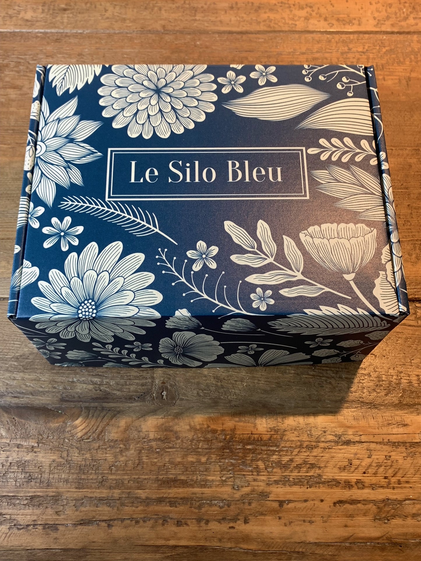 Le Silo Bleu branded premium gift box. Blue with white flowers and leaves imprinted on the box.