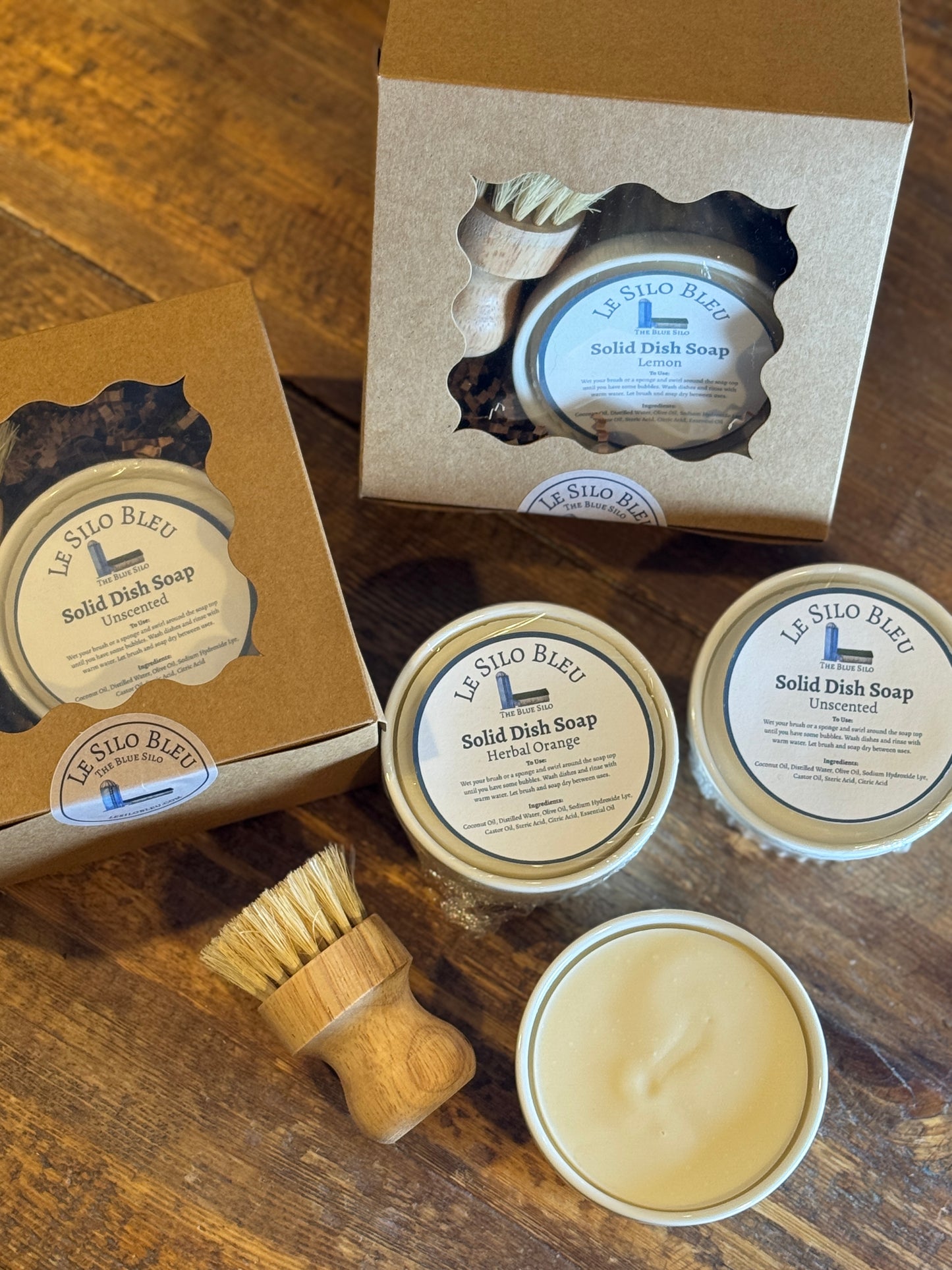 Le Silo Bleu solid dish soap sets of white ramekins with a wooden dish brush on a wooden tabletop