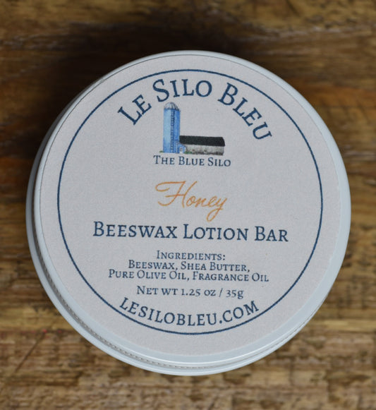 Beeswax Lotion Bar- Honey Scented in white tin on a wood counter