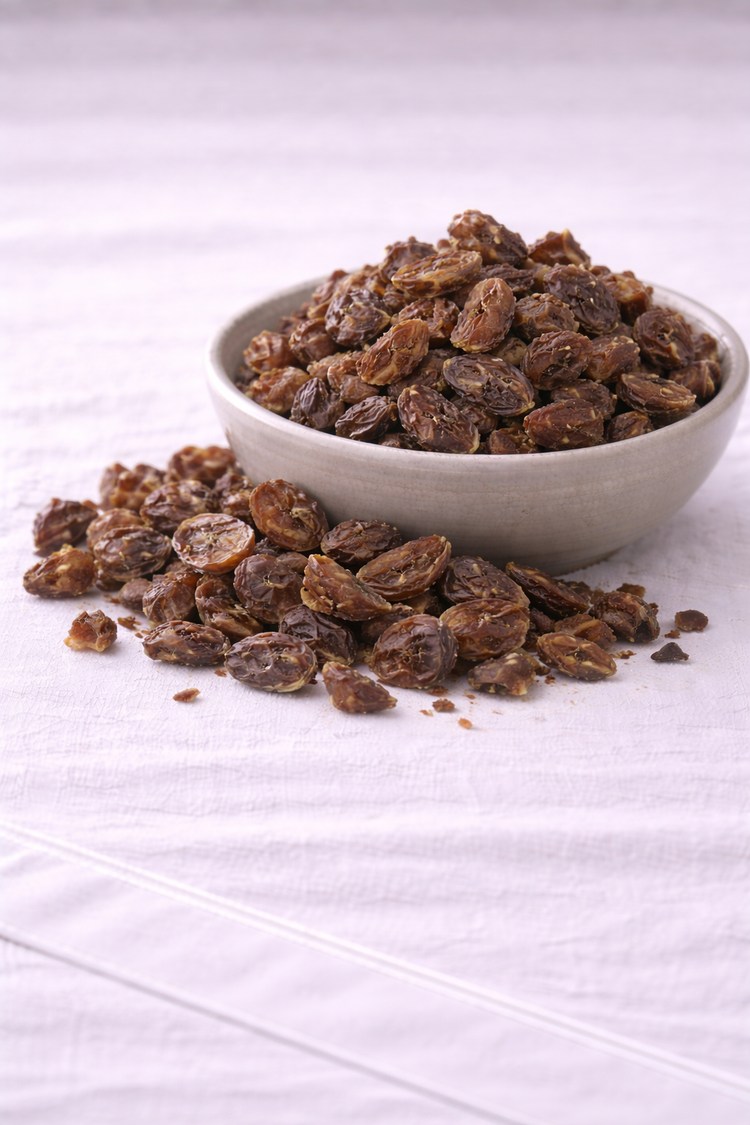 Dried alma in a rustic bowl sitting on a linen tablecloth.