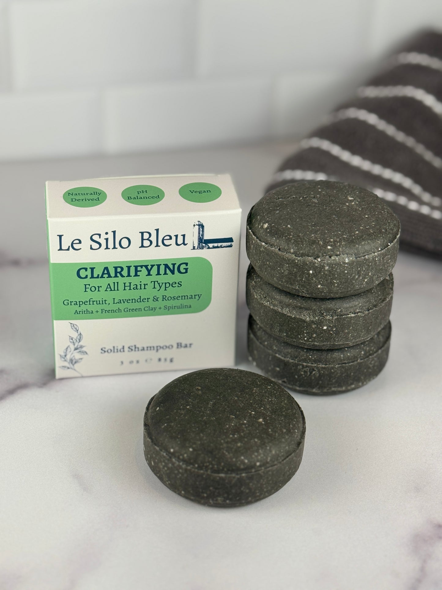 Le Silo Bleu clarifying solid shampoo bars on a marble surface with a white background highlighting the box top.