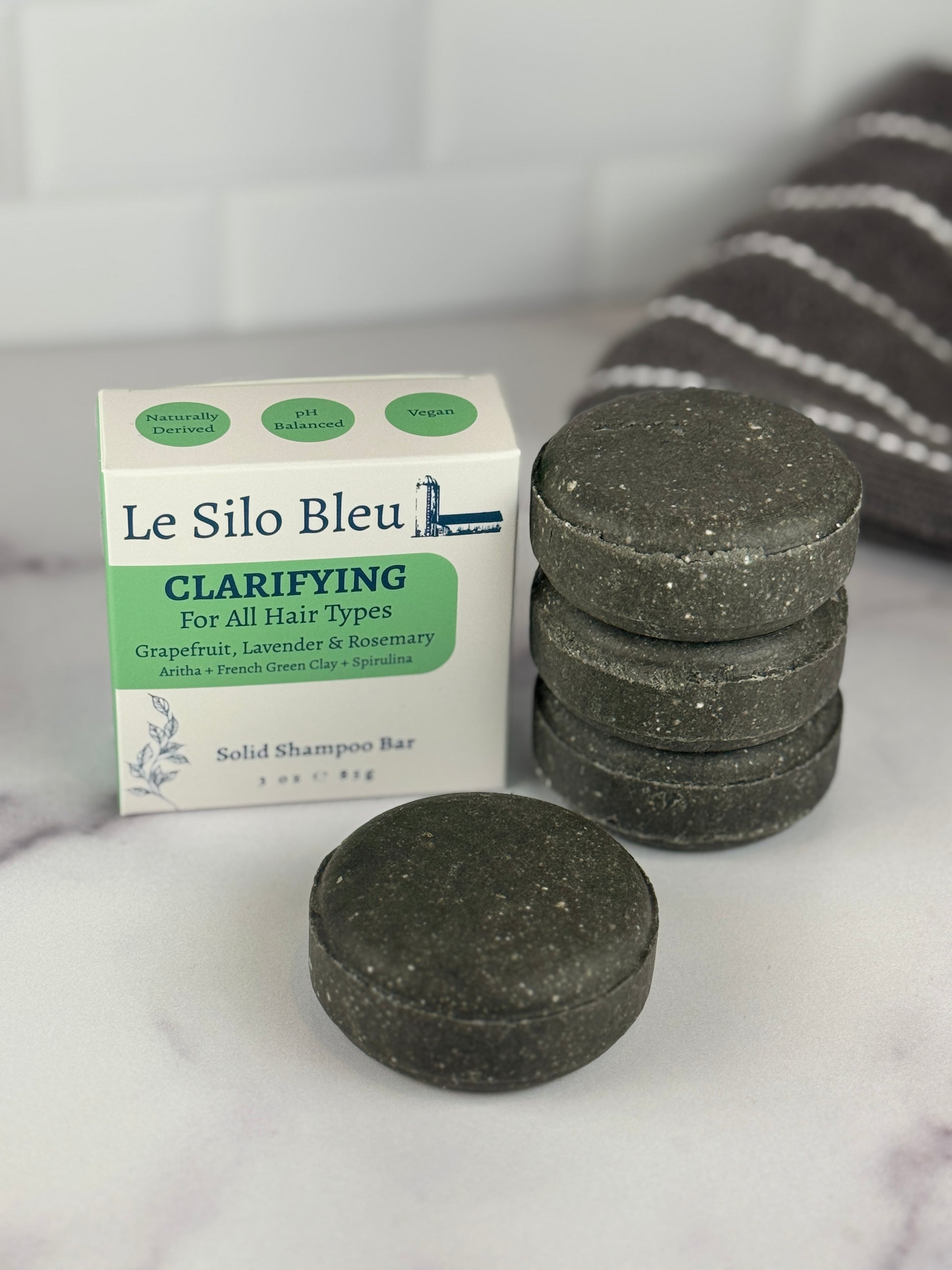 Le Silo Bleu clarifying solid shampoo bars on a marble surface with a white background highlighting the box top.
