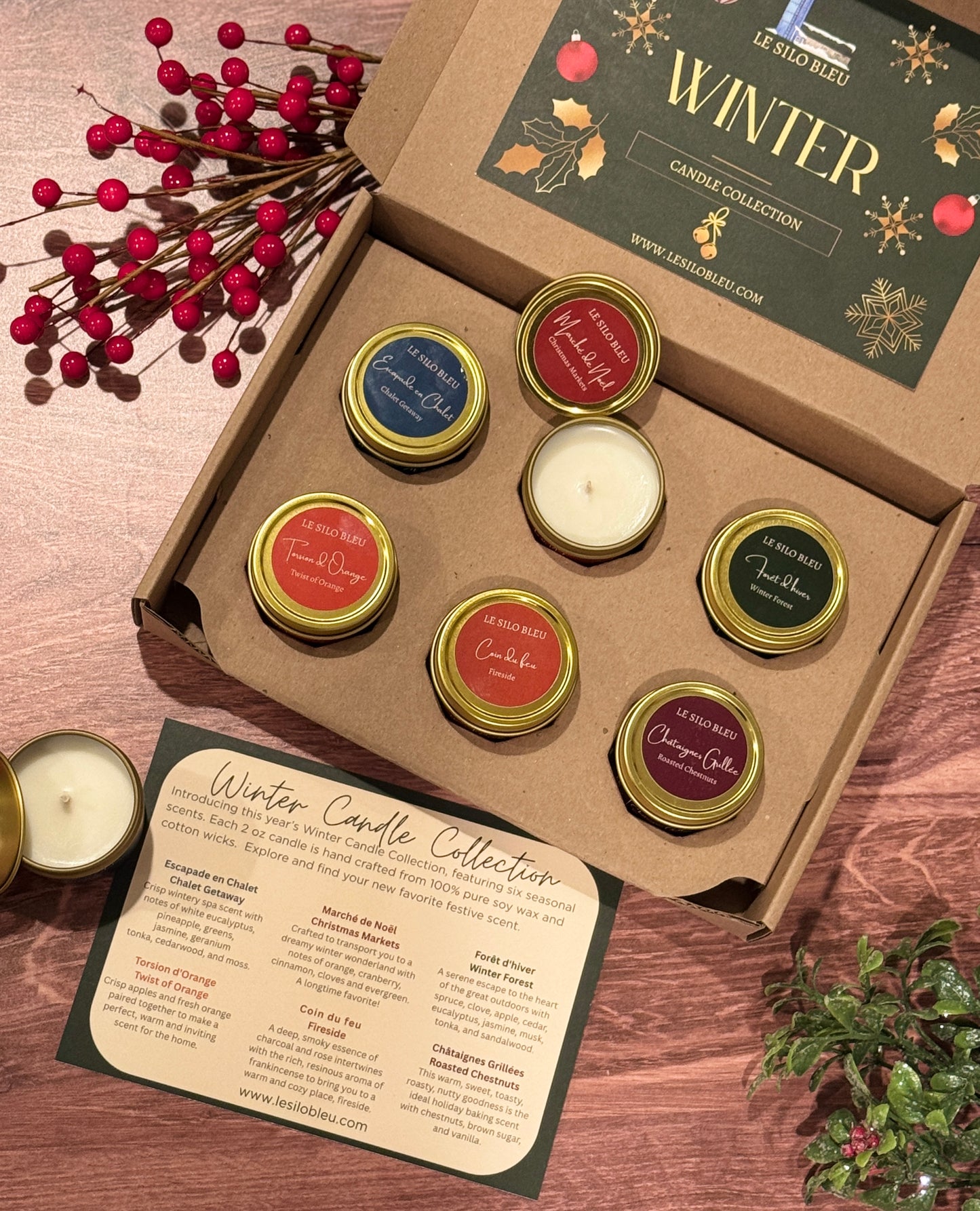 Set of six candles in a 'Winter' collection box with decorative elements on a wooden surface.