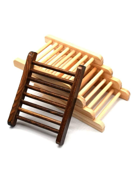 These bamboo soap trays are made of quality bamboo. Allows for complete drainage for longer lasting soap.  A stack of natural bamboo trays with a dark bamboo tray leaning on the stack with a white counter and white background.